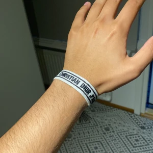 armband - Snyggt armband frå' i svart på vit bakgrund. Armbandet är vävt och har en enkel, stilren design som passar perfekt till din outfit. Perfekt accessoar för dig som gillar exklusiva märken.