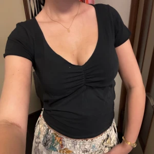 Svart topp med v-ringning - Svart topp med vringning. Mjuk och stretchig sitter perfekt på kroppen, från brandy därav one size. Perfekt skick