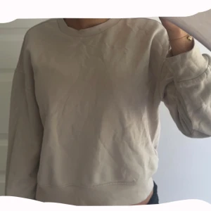 Beige sweatshirt från H&M Basic XS - Enkel och stilren beige sweatshirt från H&M Basic i storlek XS. Tröjan har rund halsringning och långa ärmar, perfekt för en chill och avslappnad look. Mjuk insida och klassisk passform som funkar till allt.