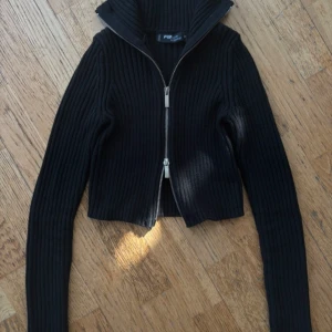Svart croppad stickad tröja med dragkedja - Jättefin stickad cropped tröja. Säljer pga för liten för mig :(