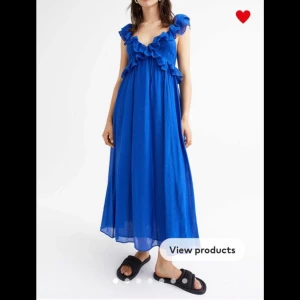 Blå volangklänning från H&M XL - Supersöt lång blå klänning från H&M med volangdetaljer och öppen rygg. Klänningen har knyt i ryggen och är ärmlös med breda axelband. Perfekt för sommarens alla tillfällen när du vill sticka ut lite extra.