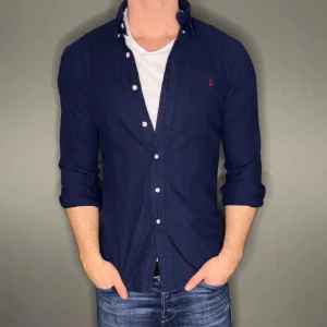 Marinblå Ralph lauren skjorta - Hej säljer nu min fina Ralph lauren skjorta i storlek XL. Den är i bra skick och kommer vara otroligt snygg nu i vår och framåt sommaren. Nypris cirka 1600kr! Vi kommer att sälja liknande produkter nu i vår och närmare sommar så glöm inte följa profilen!🌊🍾 29
