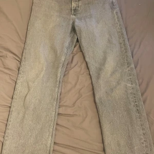 Grå raka jeans från COS, 30/32 - Snygga grå jeans från COS i rak modell med midwaist. Jeansen är i full längd och har en klassisk, stilren look som passar till det mesta. Tillverkade i jeansmaterial och perfekta för dig som gillar en enkel men trendig vibe.