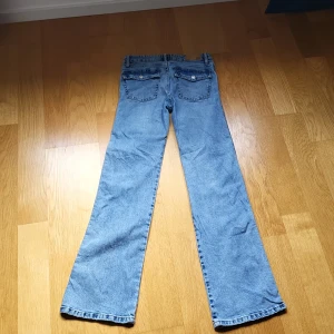 Bootcut jeans från lager 157 i ljusblå denim - Säljer ett par snygga ljusblå bootcut jeans från lager 157. Klassisk femficksmodell med raka ben och normal passform. Jeansen har en 90-talsvibe och är tillverkade i bomull. Perfekta för dig som gillar retrostilen!