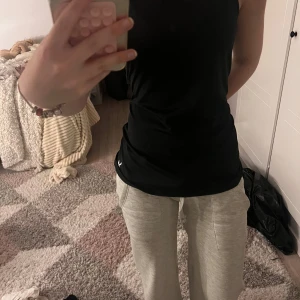 Svart linnetopp från SOC - Säljer en svart linnetopp från SOC med sportig look. Toppen är ärmlös och har en klassisk rund halsringning. Perfekt för träning eller chill dagar. Materialet är mjukt och stretchigt syntet, vilket gör den riktigt bekväm att bära.