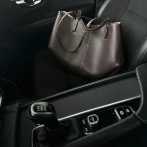 Brun  LIKLANDE  handväska  Polène ( inte äkta) - Säljer en vacker replika av Polène “Cyme” i brunt. Väskan är köpt i Europa,  använd ett fåtal gånger. Perfekt att bära på axeln eller i handen. Säljes då den tyvärr är för stor för mig(53*10,5*33 ) 