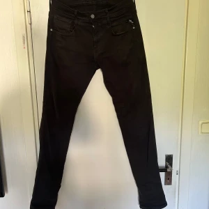 Svarta Replay jeans anbass  - Svarta jeans från Replay i modellen anbass. De är i helt perfekt skick, de ända som skulle vara lite dåligt med de är lappen på baksidan som lossnat lite men är inget stort. De är i storlek 28/32. Nypris runt 1800. Bara att Höra av dig om det är något du undrar!