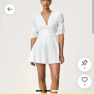 ADOORE KLÄNNING - Superfin vit kort klänning med v-ringning, puffiga halvlånga ärmar och markerad midja. Klänningen har knappar framtill och lätt utsvängd kjol. Perfekt för sommarens alla tillfällen! Endast använd 1 gång 