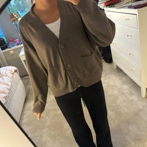 Brun kofta med knappar och fickor - Mysig brun kofta med v-ringning, stora knappar framtill och två praktiska fickor. Modellen är lite loose och har långa ärmar samt ribbade muddar. Passar mig som brukar ha S/M🥰