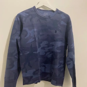 Ralph Lauren camo tröja - Hej säljer denna snygga Ralph lauren camo tröjan i storlek 170, Xs den är i 9/10 skick utan några fläckar eller skador lite tecken på användning  annars jätte bra kvalitet. Vid funderingar eller andra frågor så hör av dig, vi svarar så snabbt vi kan. Priset är inte hugget i sten!