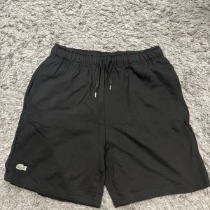 Lacoste shorts - Helt nya och oanvända Lacoste shorts, 10/10 skick. Inga skador eller defekter. Det är storlek L men passar även M. Rekommenderar starkt!