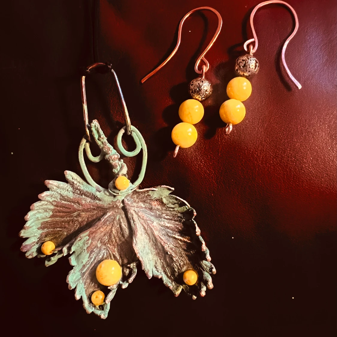 Set med örhängen och halsband med lövmotiv och gula pärlor