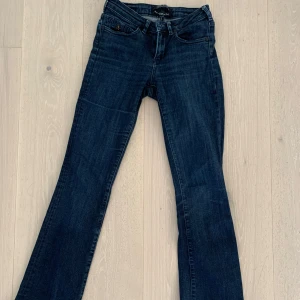 Low waist bootcut jeans från Maison Scotch - Säljer ett par mörkblå jeans från Maison Scotch, modell Jolie. bootcut-ben och normal passform. Säljer då de blivit för små. Strl 25:32