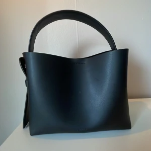 Arket väska  - Säljer min crossbody arket väska för att den inte används längre, använd ungefär 3 gånger. Har dock lite fläckar på en sida inuti väskan och utan på väskan men som knappt syns, samt är dragkedjan lite svår att dra hela vägen. Men annars en superfin och enkel handväska/axelremsväska💓originalpris:1390 sek