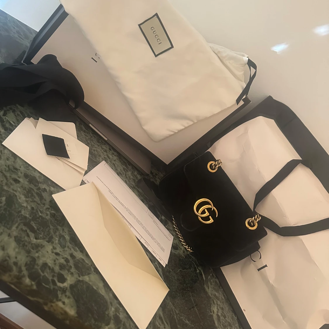 Svart axelväska från Gucci med gulddetaljer