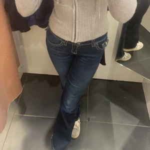 Mörkblå bootcut jeans - Säljer ett par mörkblå jeans med vita kontrastsömmar och bootcut-modell. Innerbenssömmen är 80-85cm och midjan är 80cm. Jag är 170cm