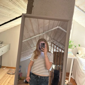 Vit och marinblå randig t-shirt från Gina Tricot - Vit t-shirt med marinblå horisontella ränder från Gina Tricot. Modellen är rak med korta ärmar och rund halsringning. Perfekt för en avslappnad och stilren look.