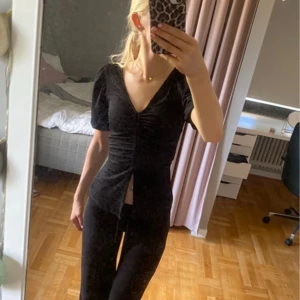 Svart topp med puffärm från Bik Bok - Säljer en svart topp från Bik Bok med puffärmar och v-ringning. Toppen har rynkade detaljer framtill och är figurnära i modellen. Perfekt att styla med både jeans och kjol. Materialet känns mjukt och stretchigt.