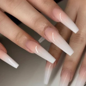 Långa gelenaglar i ombre rosa och vitt - Snygga långa gelenaglar i coffin-form med en mjuk ombre från ljusrosa till vitt. Perfekt för dig som vill ha en elegant och trendig look med extra långa naglar. 150kr