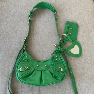 Grön axelväska med hjärtdetalj - Använd 1 gång. Köpt för ca 800kr på Ego Shoes. Inga defekter