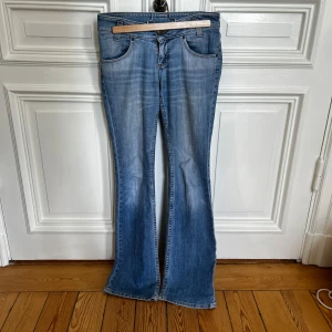 Blå bootcut jeans - Snygga blå bootcut jeans med klassisk femficksdesign och lätt slitning framtill. Jeansen har normal passform och är tillverkade i denim. Perfekta för en avslappnad stil och passar till många olika outfits. 27/32