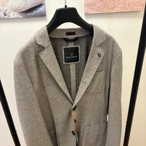 Beige/grå kavaj i kashmir - En snygg beige kavaj i kashmir material.