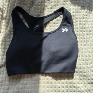 Svart sport-bh  - Säljer en svart sport-bh  i storlek XS. Modellen har brottarrygg och är tillverkad i ett stretchigt syntetmaterial som passar perfekt för träning. Enkel och stilren design med logga framtill💞💞
