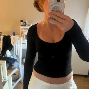 Svart croppad långärmad topp från H&M Divided - Säljer en svart, croppad långärmad topp från H&M Divided. Toppen har en rund halsringning och är tillverkad i ett mjukt bomullsmaterial. Perfekt att matcha med både jeans och kjol för en enkel och stilren look. Hör av er vid fler frågor eller bilder.💛