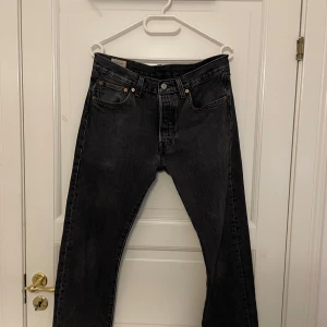 Svarta Levi's 501 jeans - Säljer ett par svarta Levi's 501 jeans med klassisk rak passform. Jeansen har fem fickor, knappgylf och är tillverkade i robust denim. Perfekta för dig som gillar tidlös stil och vill ha ett par jeans som funkar till det mesta. 31, 32