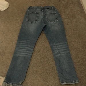 Blå jeans från Calvin Klein Jeans - Snygga blå jeans från Calvin Klein Jeans med klassisk femficksdesign och broderad logga på fickan. Jeansen har normal passform, raka ben och är tillverkade i slitstarkt denim. Perfekta för dig som gillar en tidlös och clean look.