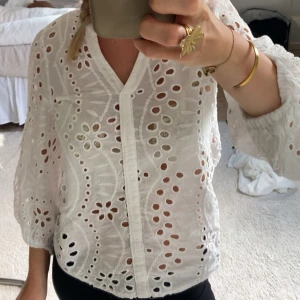 Vit blus  - Superfin vit blus med broderade blommor och hålmönster. Det va knappar i mitten innan men har tagit bort dem och sytt ihop framtill💖Köpte av en kompis för länge sen och finns ingen lapp så vet inte storlek eller märke men skulle gissa på xs/s 💕 