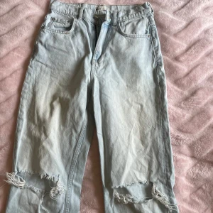 Ljusblå ripped jeans från g perfect jeans/Gina Tricot - Säljer ett par ljusblå jeans från g perfect jeans (Gina Tricot) i storlek 34. Jeansen har raka ben, hög midja och slitna detaljer vid knäna för en cool, avslappnad look. Klassisk femficksmodell i mjukt denimtyg. 