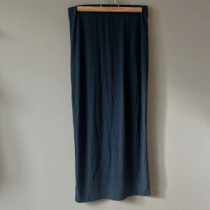 Mörkblå långkjol från 157 - Enkel och stilren mörkblå långkjol från 157. Kjolen har rak passform och resår i midjan för extra komfort. Perfekt att styla med sneakers eller boots för en chill look.