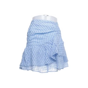 Ljusblå randig volangkjol - Superfin ljusblå kortkjol med randigt mönster och volangdetaljer. Kjolen har omlottkänsla och är gjord i ett lätt, luftigt material som passar perfekt till varma dagar.