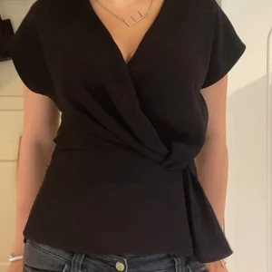 Svart omlottopp med knyt - slutsåld omlott blus från zara, helt slutsåld o säljs inte längre!!💝 även mycket efterfrågad😍superfint skick!! Liiiite nopprig på ett litet ställe  men inget som syns