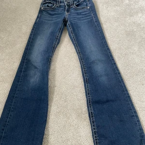 Blå bootcut jeans från Gina Tricot, stl 152 - Snygga blå jeans från Gina Tricot i storlek 152. Klassisk femficksmodell med kontrastsömmar och raka ben. Jeansen har normal passform och är tillverkade i mjukt denimtyg med lätt tvättad look. Perfekta till en avslappnad stil.