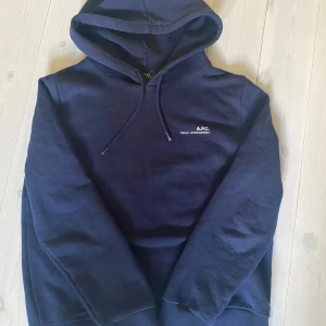Mörkblå hoodie från A.P.C. - Fet mörkblå hoodie från A.P.C. Inköpt från cettire. Killen på bilden är 173.  Skick 9/10 använd fåtalet gånger och inga defekter! Storlek s i dam men skulle säga att den passar som ungefär xs för herr. Pris kan diskuteras!