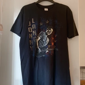 Lang band t-shirt  - Svart t-shirt från  med coolt tryck på framsidan och turnédatum på baksidan. Klassisk passform, korta ärmar och rund hals. 