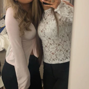 Vit spetsblus med lång ärm - Superfin vit blus i spets med blommigt mönster och långärmad design. Toppens genombrutna spets ger en snygg och trendig look, perfekt att styla med svarta jeans eller kjol. Hög halsringning och figurnära passform för en chic vibe.