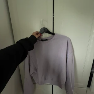 Ljuslila sweatshirt från BikBok - En stilren ljuslila sweatshirt från BikBok i storlek S. Tröjan har en klassisk rund halsringning, ribbade muddar och är i en loose passform. Perfekt för dig som gillar en enkel och avslappnad look. Materialet är mjukt och skönt, troligtvis bomullsmix.