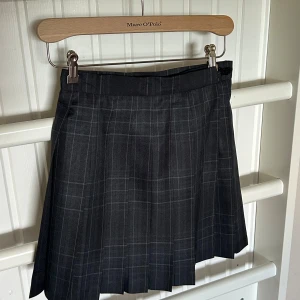 Plisserad kjol  - Inköpt på Comic con, troligtvis del av skoluniform. Aldrig använd. Går att göra mindre/större med hjälp av spänne (se bild)