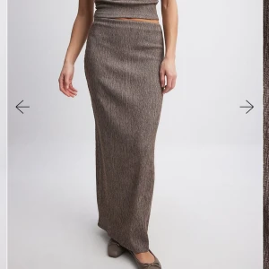 Kjol - Brun långkjol från NA-KD i strukturerat tyg med diskret mönster. Kjolen har en rak passform, hög midja och slits bak. Helt oanvänd med alla lappar kvar💌