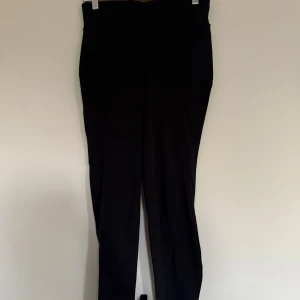 Svarta leggings från Lululemon, stl 8 - Svarta leggings från Lululemon i storlek 8. De är högmidjade och har en tight passform, perfekta för träning eller chill. Tillverkade i ett stretchigt material av 84% nylon och 16% elastan för maximal komfort och rörelsefrihet.