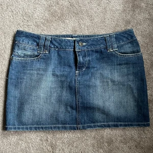 Jeanskjol från ONLY med fickor - Snygg blå jeanskjol från ONLY med klassisk femficksdesign, bälteshällor och dragkedja fram. Bakfickorna har coola sömmar och en liten röd ONLY-tag. Perfekt till sneakers eller boots för en chill look. Se mått sista bilderna 