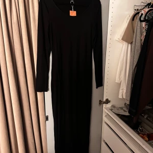 Svart långklänning från SHEIN - En stilren svart långklänning från SHEIN i storlek M. Klänningen har lång ärm och en enkel, figurnära passform med rundad halsringning. Aldrig andvänd!