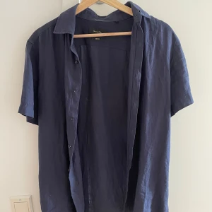 Mörkblå linneskjorta från Massimo Dutti - Mörkblå skjorta i 100% linne från Massimo Dutti. Använd på sin höjd 5 gånger. Har endast hängt i garderoben efter det. Inga defekter av något slag. 