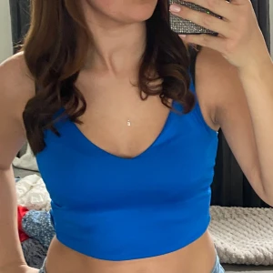 Blå croppad linnetopp - Snygg blå croppad linnetopp med v-ringning. 