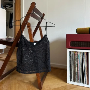 Svart spetslinne från H&M Divided - Säljer ett svart spetslinne från H&M Divided. Linnet har tunna axelband och ett vackert spetsmönster. Lite nopprig men annars nyskick 