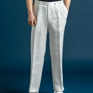 Vita linnebyxor från Oscar Jacobson - Snygga vita linnebyxor från Oscar Jacobson.  I mycket bra skick, använd endast ett fåtal ggr. Nypris 2 199kr. Säljer för 900kr eller bud. De har en klassisk rak passform och är tillverkade i 100% linne. Byxorna har en stilren design med knappar och fickor baktill. 