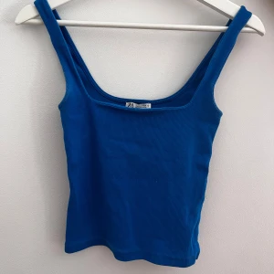 Blå ribbad linnetopp från Zara - Snygg blå ribbad linnetopp från Zara med breda axelband. Perfekt för sommardagar och kan enkelt matchas med olika outfits. Ett måste i garderoben för en stilren look.